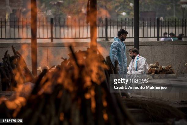 Man performs the last rites for his wife who died of the Covid-19 coronavirus disease during a mass cremation at a crematorium on April 20, 2021 in...
