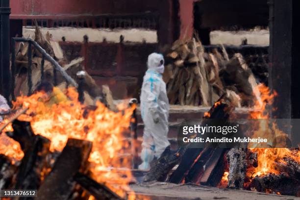 Man wearing PPE performs the last rites to his relative who died of the Covid-19 coronavirus disease at a crematorium on April 20, 2021 in New Delhi,...