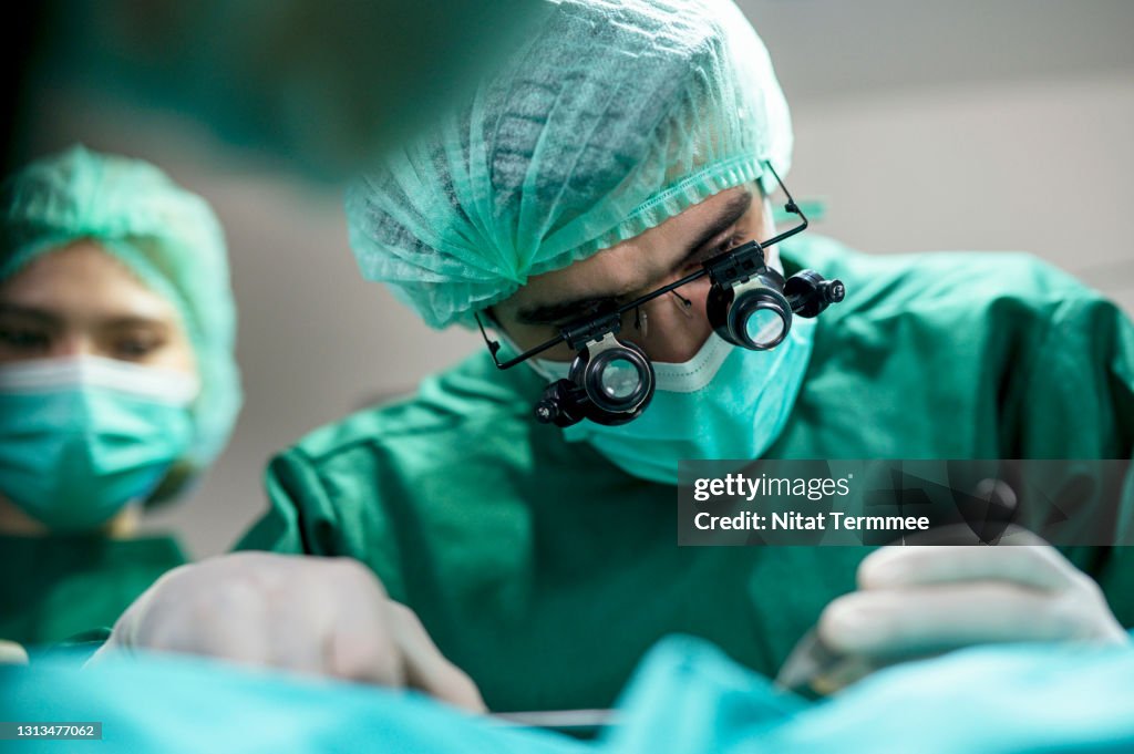 The Business of Plastic surgery. Surgeons operating patient for breast implant in Surgery Clinic.