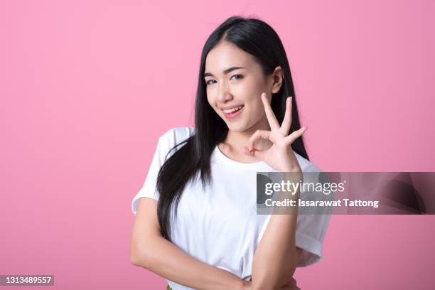 young asian woman showing a ok hand sign. - ok zeichen stock-fotos und bilder