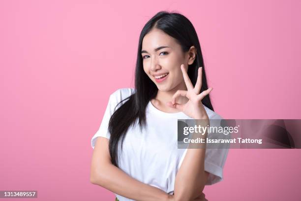 young asian woman showing a ok hand sign. - okサイン　女性 ストックフォトと画像