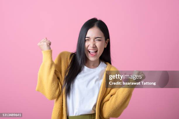 image of excited young lady standing isolated over pink background make winner gesture. - euforia imagens e fotografias de stock