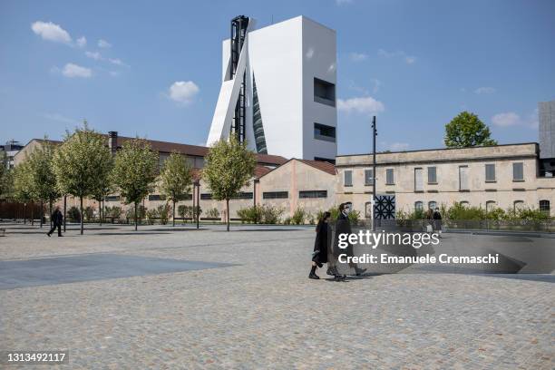People stroll at Piazza Olivetti, a new square located in front of Fondazione Prada, part of the Symbiosis business district on April 20, 2021 in...