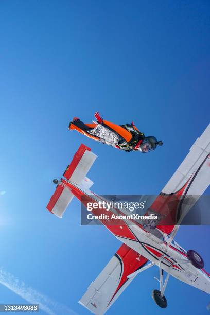 wingsuit-flieger springen aus dem flugzeug in der luft - kunstflug stock-fotos und bilder