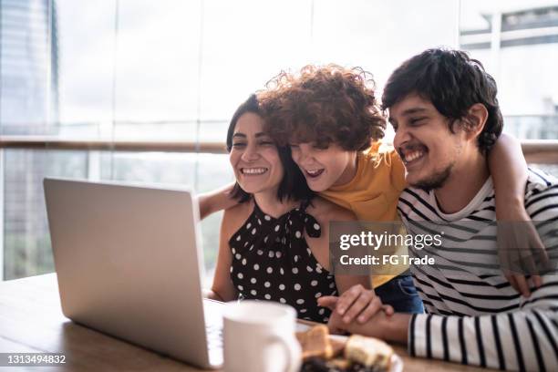 famiglia che guarda un film o fa una videochiamata su laptop a casa - famiglia multimediale foto e immagini stock
