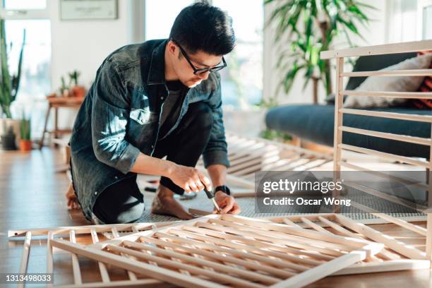 young father assembling baby cot at home - furniture imagens e fotografias de stock