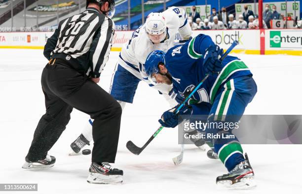 Jason Spezza of the Toronto Maple Leafs and Brandon Sutter of the Vancouver Canucks battle for the puck on a face-off during NHL hockey action at...