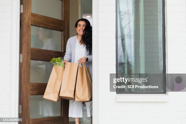 woman picks up contactless grocery order - stoop stock pictures, royalty-free photos & images