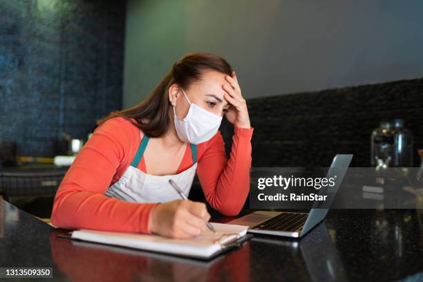 university student waitress trying to study during break hours in her cafe - overworked waitress stock pictures, royalty-free photos & images