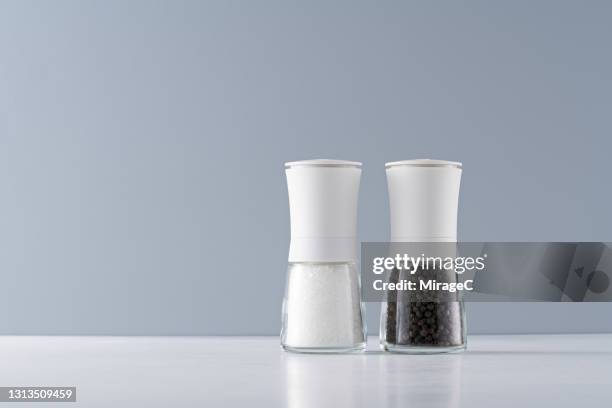 white sea salt and black pepper mills - salt shaker ストックフォトと画像