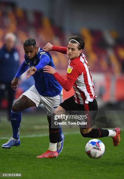 Mathias Jensen of Brentford is challenged by Leandro Bacuna of Cardiff City during the Sky Bet Championship match between Brentford and Cardiff City...