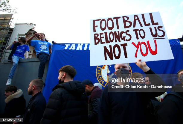 Fans hold banners opposing Chelsea signing up for the newly proposed European Super League ahead of the Premier League match between Chelsea and...