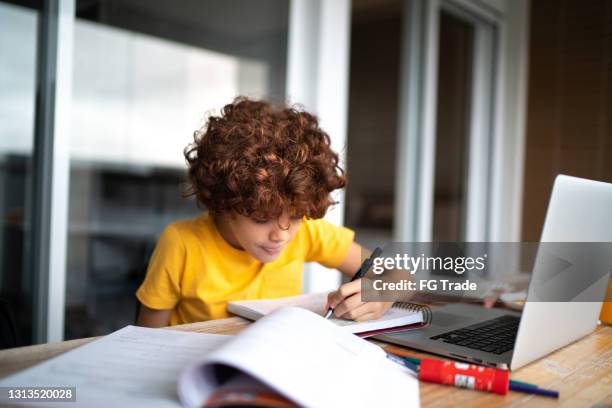 garçon étudiant utilisant l’ordinateur portatif à la maison - élève 12 ans photos et images de collection