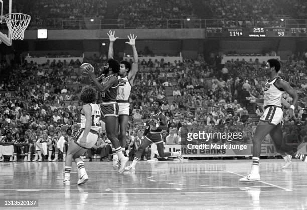 New York Knicks guard Ticky Burden drives for a layup through Denver Nuggets guards Monte Towe and Chuck Williams during an NBA basketball game at...