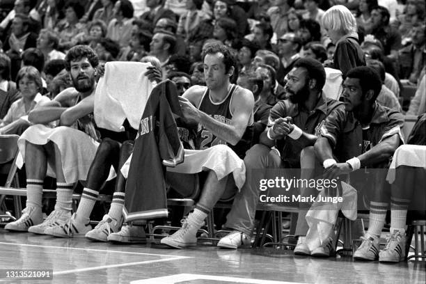 New York Knicks forward Bill Bradley puts on his warmup jersey as he sits on the bench during an NBA basketball game against the Denver Nuggets at...