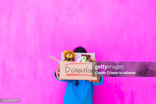 unrecognizable young woman with a gift box with toys - selfless - fotografias e filmes do acervo