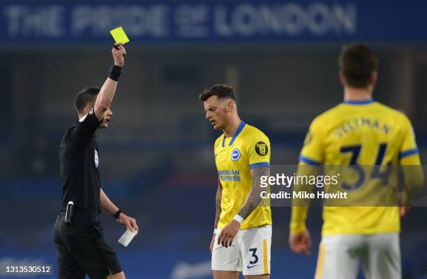 Ben White of Brighton & Hove Albion is shown a yellow card by referee Stuart Attwell during the Premier League match between Chelsea and Brighton &...