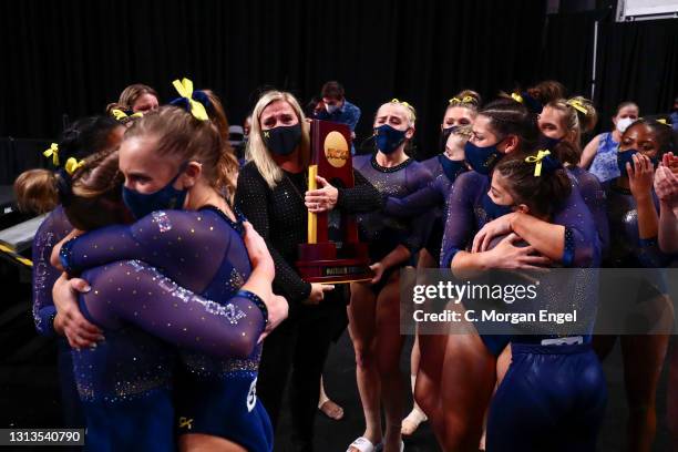 Head coach Bev Plocki of the Michigan Wolverines holds the national championship trophy as her athletes react during the Division I Women’s...