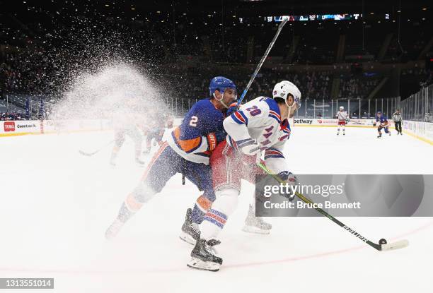Nick Leddy of the New York Islanders checks Chris Kreider of the New York Rangers during the first period at the Nassau Coliseum on April 20, 2021 in...