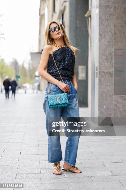 Influencer Gitta Banko wearing a dark grey leopard print scarf by Simone Bruns, a turquoise bag with black leopard print and a gold chain by Saint...