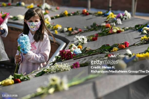 Jazzy Muñoz leaves flowers on the names of each victim at the Columbine Memorial at Robert F. Clement Park on April 20, 2021 in Littleton, Colorado....