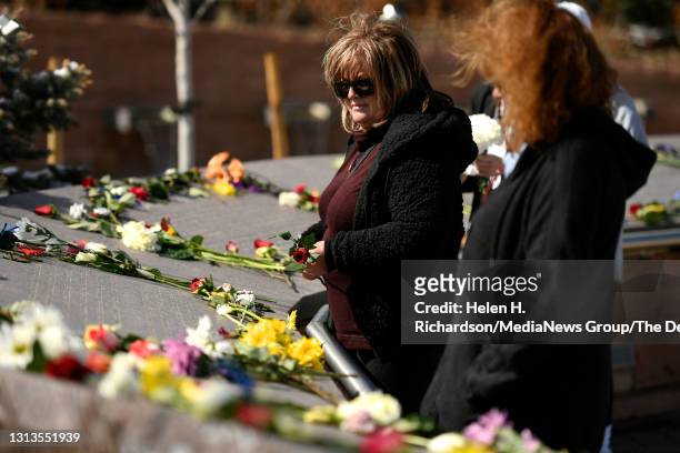 Sue Petrone, second from right, the mother of Columbine victim Daniel "u201cDanny"u201d Rohrbough places a red rose on the names of each victim at...