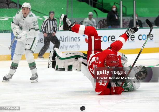 Jake Oettinger of the Dallas Stars trips Darren Helm of the Detroit Red Wings in the third period at American Airlines Center on April 20, 2021 in...