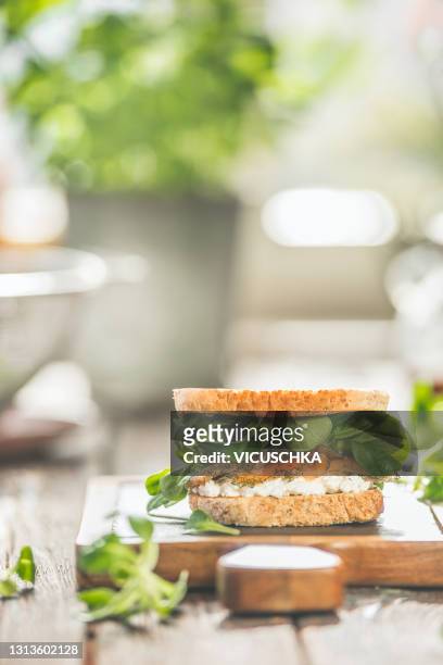 sandwich with salmon, salad and cream cheese on kitchen table at window. healthy lunch. - toasted bread stock-fotos und bilder