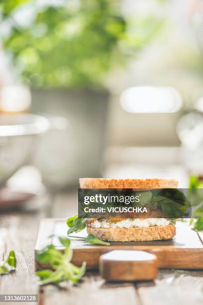 sandwich with salmon, salad and cream cheese on kitchen table at window. healthy lunch. - cream cheese stock pictures, royalty-free photos & images