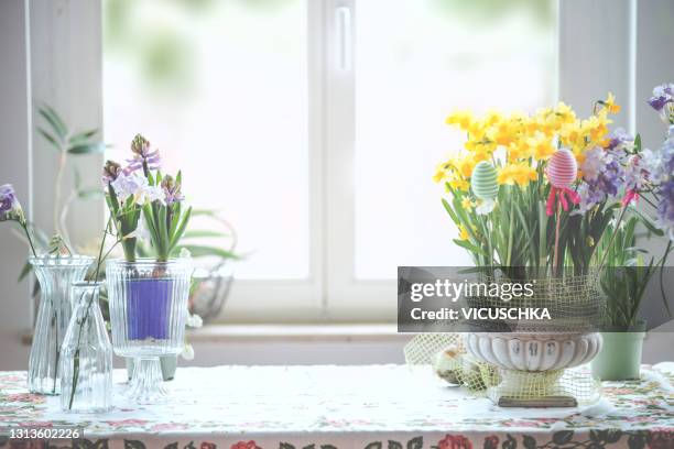 still life background with springtime flowers and easter eggs on kitchen table at window background - easter flowers stock pictures, royalty-free photos & images