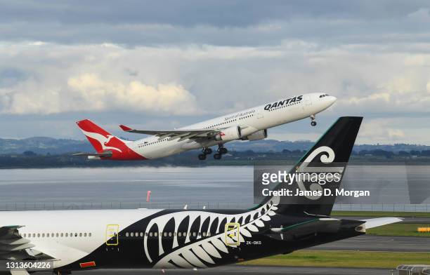 Qantas Airbus A330 aircraft takes off destined for Sydney next to Air New Zealand aircraft at the International Airport on April 19, 2021 in...