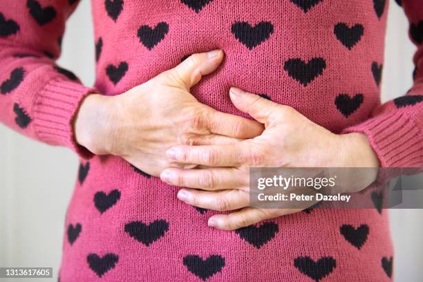 woman with pain, massaging herself - ghiandola intestinale foto e immagini stock