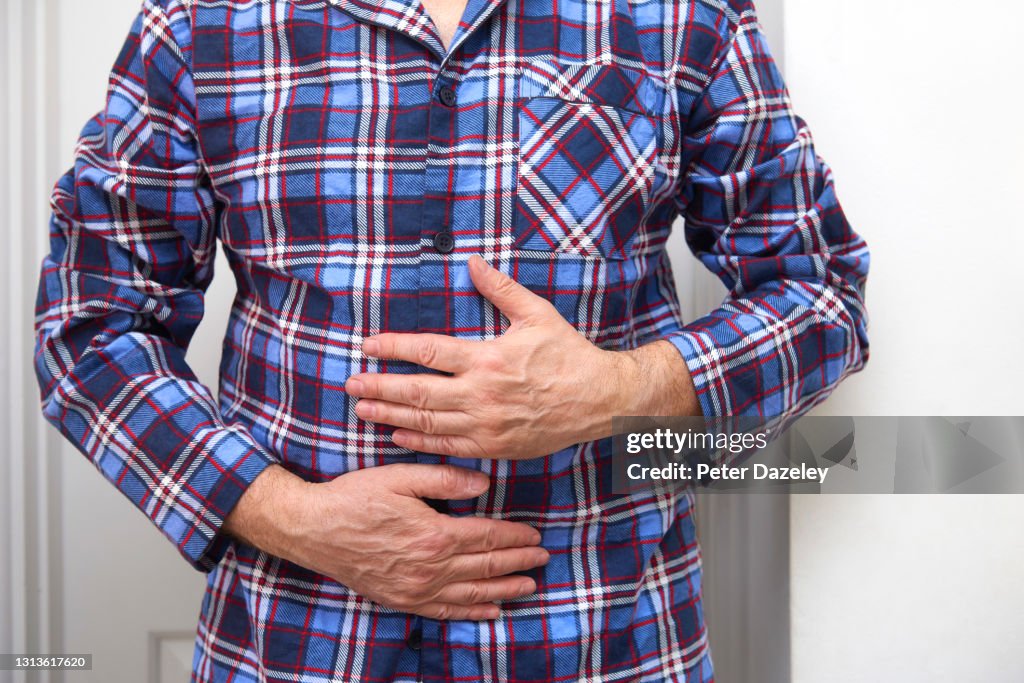 Man in pyjamas with sore tummy