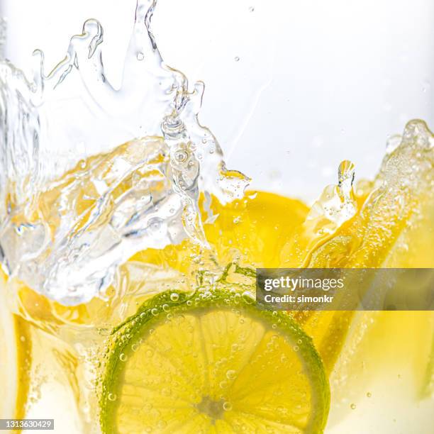 gin and tonic with lemon and lime - splashing cocktail stock pictures, royalty-free photos & images