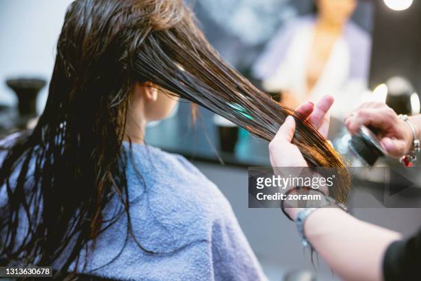 cepillarse el pelo de la mujer en la peluquería - combing fotografías e imágenes de stock