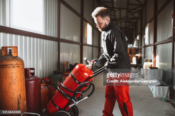 arbeiter in verflüssigter gasspeicher zieht großen zylinder - argon stock-fotos und bilder