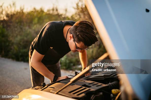 man repairing car on road - engine failure stock pictures, royalty-free photos & images