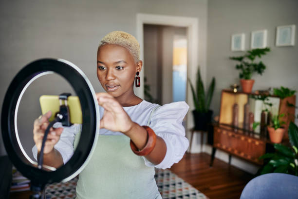 Young African influencer adjusting her smart phone before a vlog post