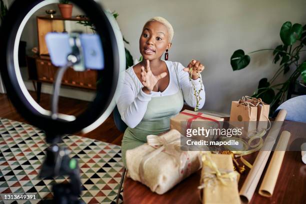 Young African woman doing a vlog post on gift wrapping
