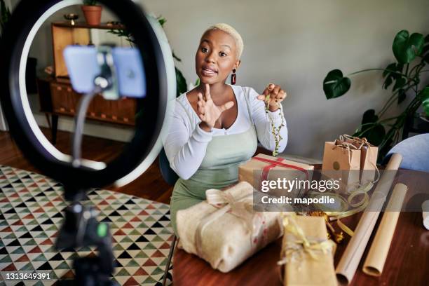 young african woman doing a vlog post on gift wrapping - social media marketing stock pictures, royalty-free photos & images