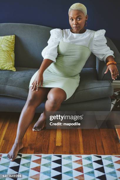 stylish young african woman relaxing on a sofa at home - plus size model stock pictures, royalty-free photos & images