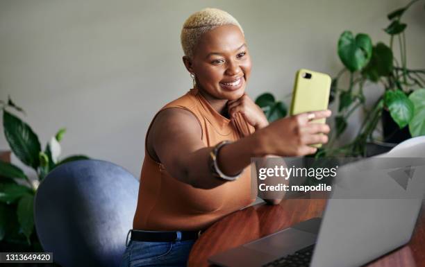 sorridente giovane donna africana che scatta selfie e usa un laptop a casa - blonde woman selfie foto e immagini stock