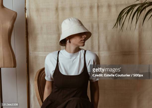 stylish and fashionable young woman sitting bucket hat,avignon,france - bucket hat stock pictures, royalty-free photos & images