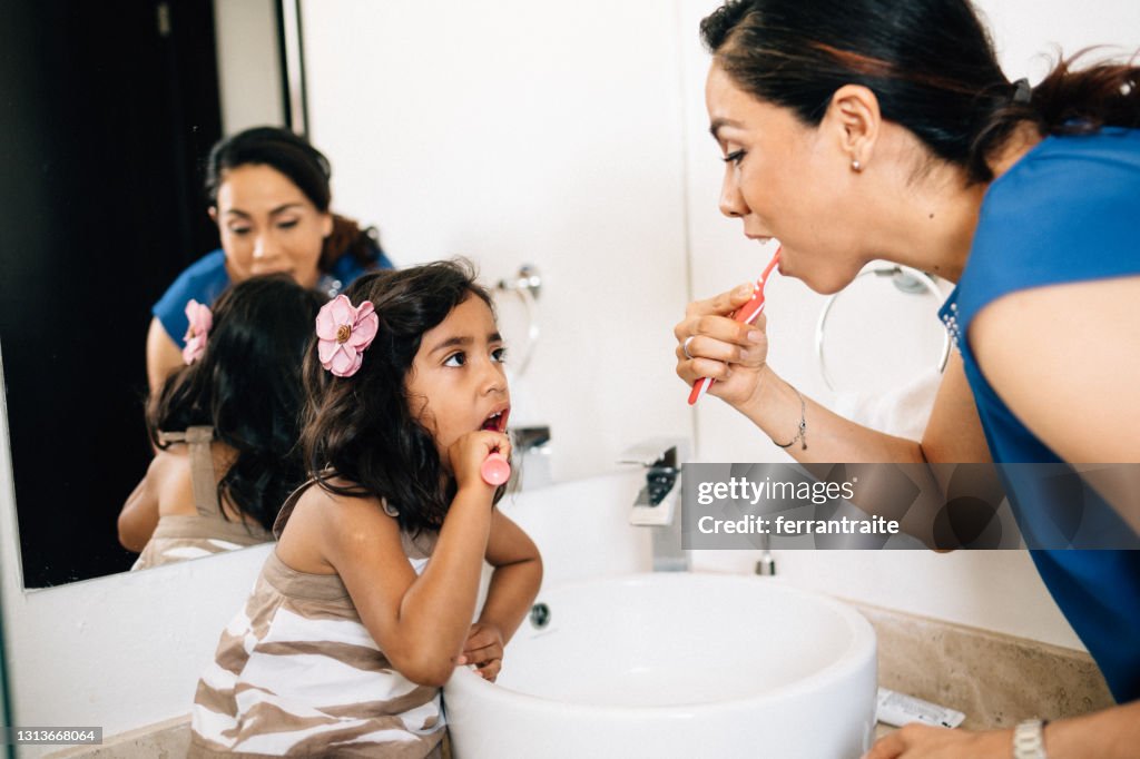 Mother and daughter brushing teeth