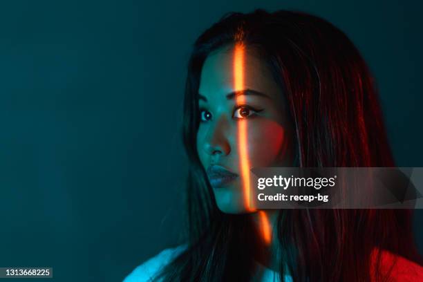 portrait of beautiful woman lit by neon colored lights - beautiful female face stock pictures, royalty-free photos & images