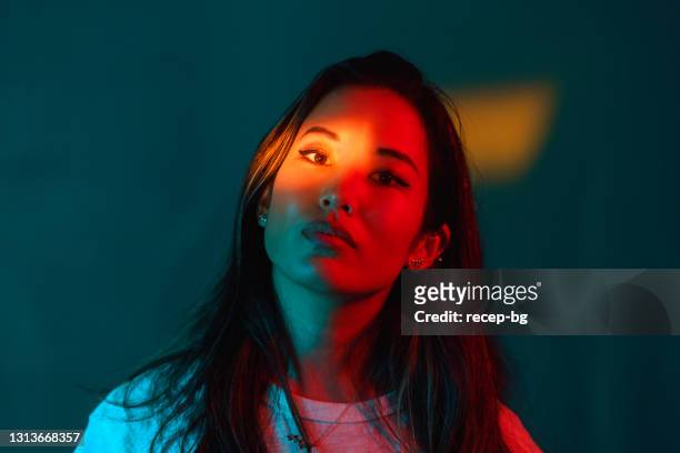 porträt der schönen frau von neon farbigen lichtern beleuchtet - asian woman model stock-fotos und bilder