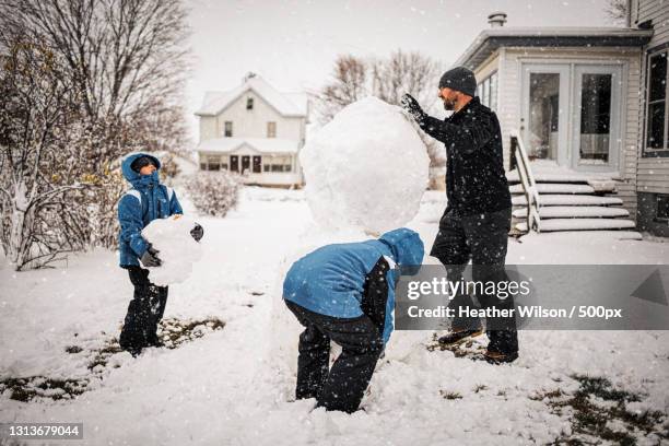 father and son building a snowman,lena,illinois,united states,usa - schneemann bauen stock-fotos und bilder