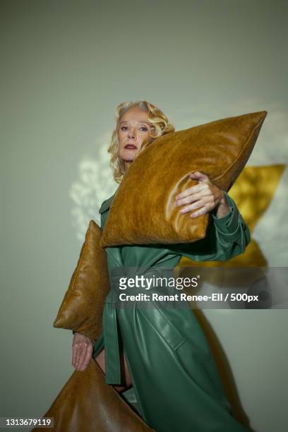 mature older woman in fashionable clothing in a room with ethereal like refractions,russia - leather dress stockfoto's en -beelden