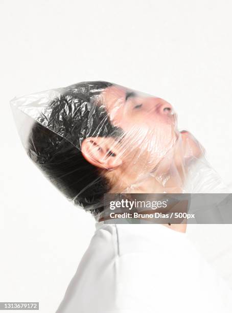 profile of young man with plastic bag over head,birigui,brazil - suffocated stock-fotos und bilder