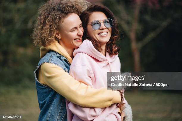 lesbian couple hanging out in a park filled with sakura trees,thailand - asian lesbians kiss stock pictures, royalty-free photos & images
